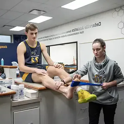 student 体育教练 treating athlete.
