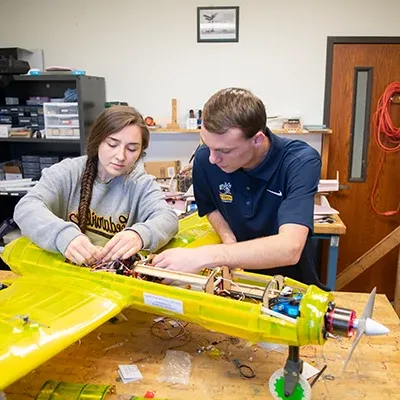 学生们正在研究一架大型半透明遥控电动螺旋桨飞机.