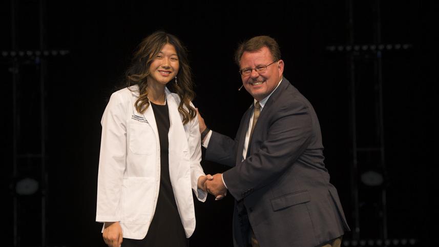 Pharmacy student receives her white coat at Cedarville University.
