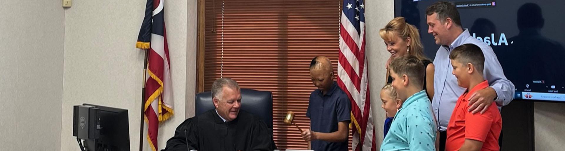 乔伊·布朗在法庭上敲响了小木槌，正式宣布他被布朗一家收养.