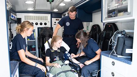 紧急医疗服务系统的学生工作人员与一名病人在紧急医疗服务系统的车上